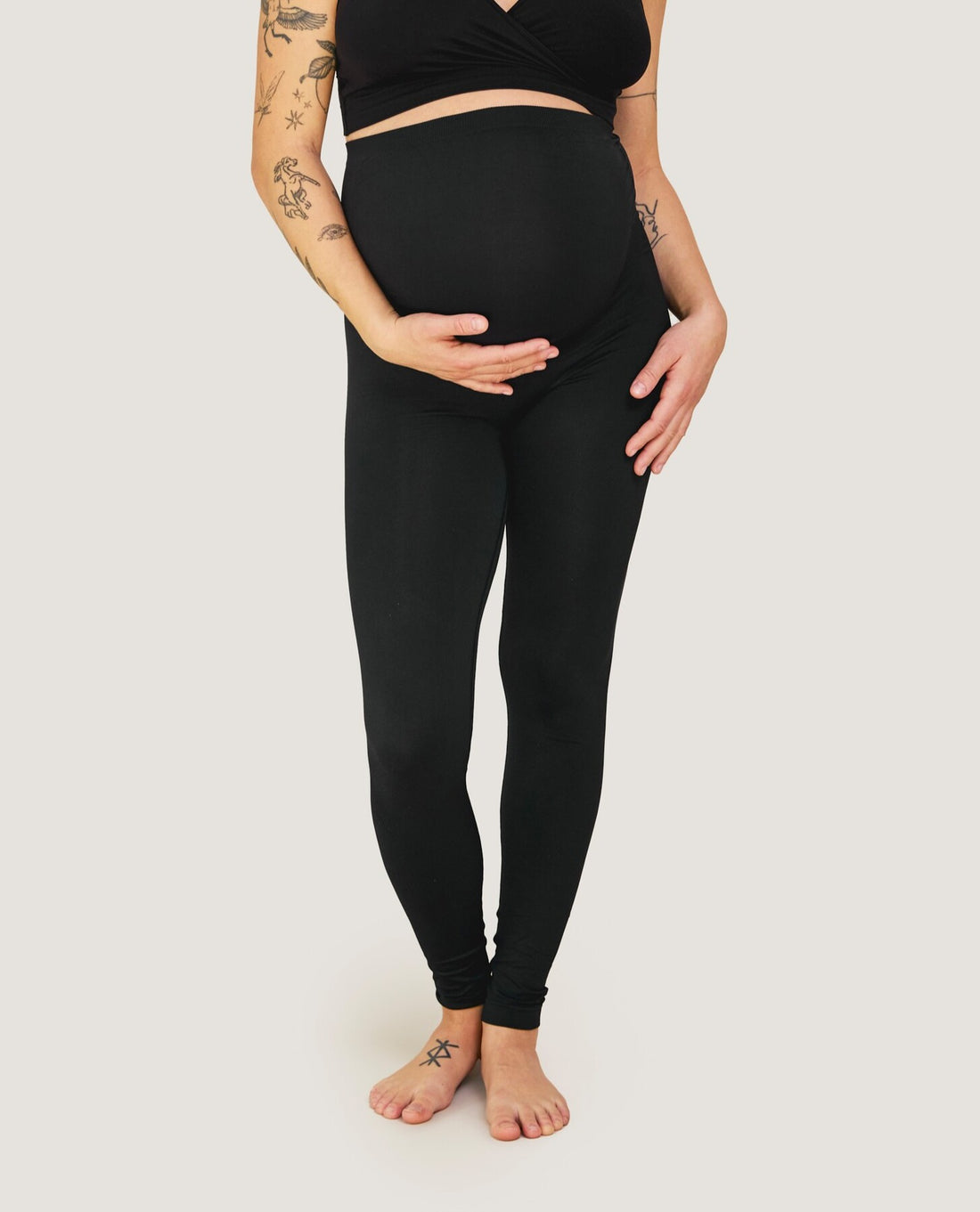 Zwangere vrouw, gekleed in zwarte Carriwell naadloze legging met steunpaneel over de buik